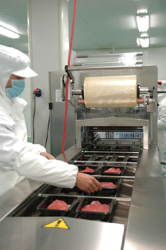 科尔沁牛业北京加工中心的工人在气调保鲜包装生产上工作。